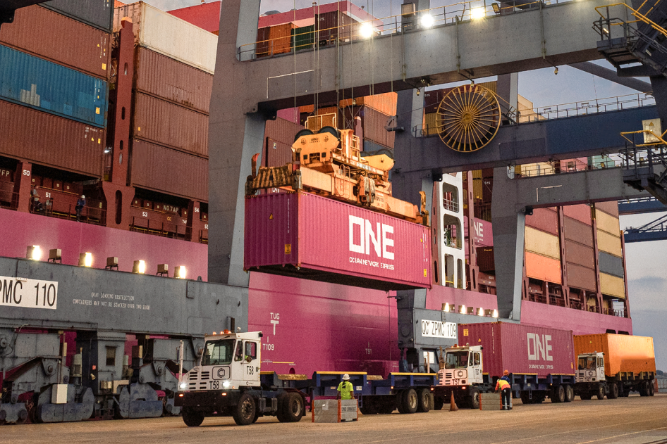 ONE shipping container being lifted by a port crane onto an ocean vessel